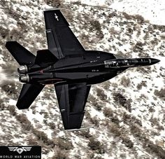 an air force jet flying through the sky over snow covered ground with trees in the background