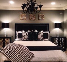 a black and white bed in a bedroom with two lamps on either side of it