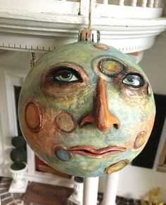 a ceramic face ornament hanging from a ceiling