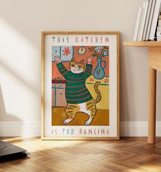 this kitchen is for dancing poster hangs on the wall next to a table with books