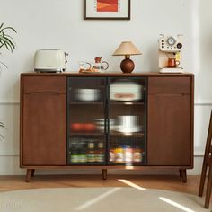 a brown cabinet sitting in the corner of a living room next to a lamp and chair