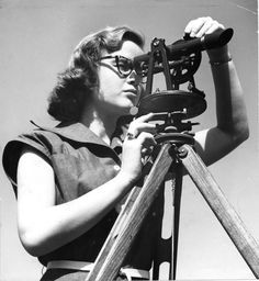 an old photo of a woman looking through a telescope