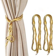 two gold colored curtain ties and some white curtains with gold metal hardware on them, next to a pair of beige linen draperies