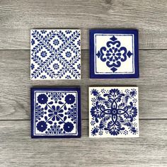 three blue and white tile coasters sitting on top of a wooden table