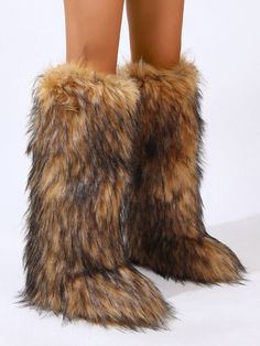 a woman's legs in furry boots on a white background with the bottom part of her boot showing