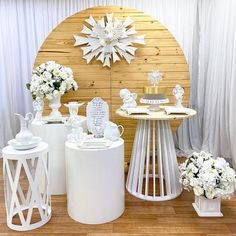 several white vases with flowers in them on display