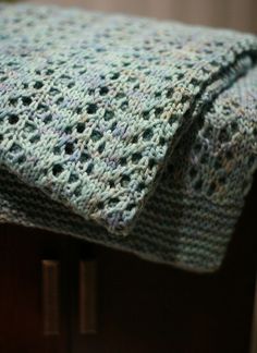 a crocheted blanket sitting on top of a wooden table