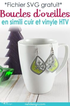 a cup with some earrings on it next to a christmas tree and the words free svg file fax leather and htv feste earrings