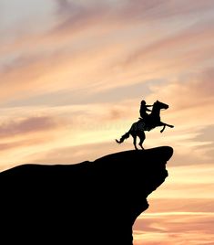 the silhouette of a man riding a horse on top of a cliff at sunset royalty photo