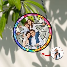 a stained glass ornament with a family photo hanging from it's side