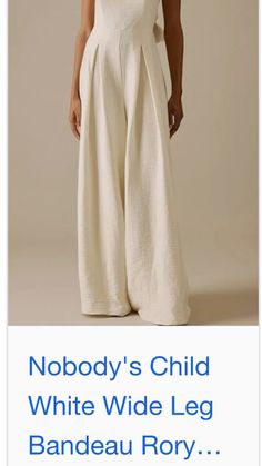 a woman wearing white wide leg pants with the words nobody's child written on it