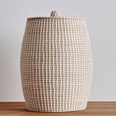 a white basket sitting on top of a wooden table