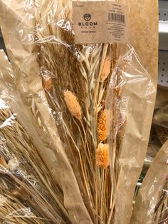 dried flowers are wrapped in plastic bags on the shelf at a grocery store for sale