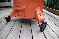 an orange cooler sitting on top of a wooden deck