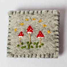 a close up of a small piece of felt with mushrooms on it and stars in the background