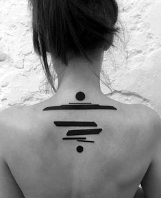 the back of a woman's neck with black ink on it