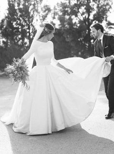 a bride and groom walking down the street