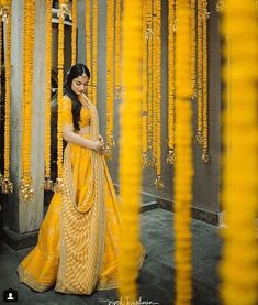 a woman standing in front of some yellow garlands and looking at her cell phone