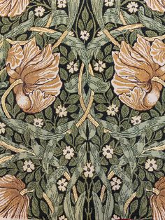 an intricately designed wallpaper with flowers and leaves in green, brown, yellow and white colors