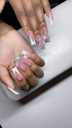 a woman's hands with pink and white manies on their nails, holding onto a plastic object