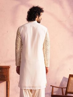 Vastramay Men's Cream Georgette Embellished Kurta A classic choice for any occasion, this cream georgette kurta is elegantly embellished for a sophisticated look. Crafted with care, it offers both style and comfort. Key Features: Cream colored georgette fabric Embellished design for a touch of elegance Mandarin collar Long regular sleeves Straight cut, knee-length silhouette Specifications Sleeve Length - Long Sleeves Top Shape - Straight Top Hemline - Straight Top Length - Knee Length Neck Mand Georgette Kurta, Men Cream, Sophisticated Look, Georgette Fabric, Sleeves Top, Collar Top, Mandarin Collar, Top Pattern, Straight Cut