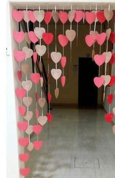 a hallway with hearts hanging from the ceiling and some sticks sticking out of the floor