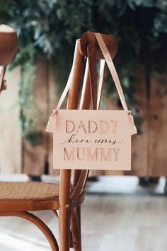 a wooden chair with a sign that says daddy here is my mommy hanging from the back