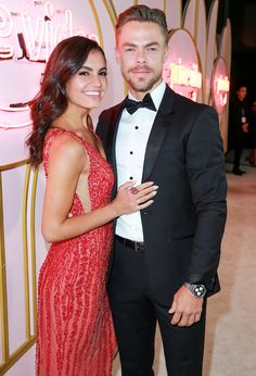 a man in a tuxedo standing next to a woman in a red dress