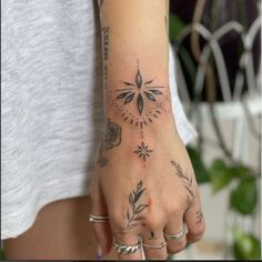 a woman's hand with tattoos on it, and an arrow in the middle