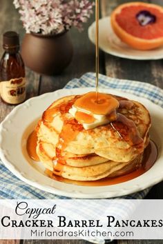 a stack of pancakes on a plate with syrup being drizzled over them