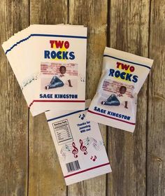 three books with two rocks on them sitting on top of a wooden table next to each other