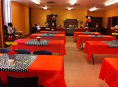 a dining room with red table cloths and mickey mouse decorations