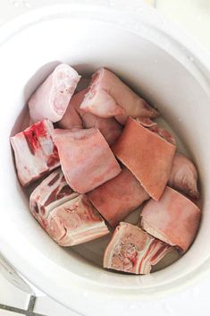 raw meat in a white bowl on top of a counter