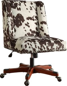 an office chair with a cow print upholstered on it's back and wheels