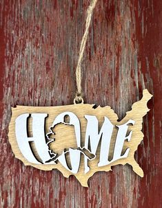 a wooden ornament with the word home hanging on a red wood door that says home