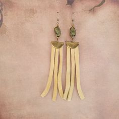 These gorgeous earrings have a drop length of 5.75 inches. The soft tan fringe is genuine leather. The beads are ceramic and look like exotic reptile skin! The earrings are hypoallergenic high quality stainless steel. This is the perfect style for anyone looking for a bold, bohemian look. Adjustable Gold Tassel Earrings With Fringe, Adjustable Fringe Tassel Dangle Earrings, Adjustable Gold Bohemian Tassel Earrings, Gold Tassel Earrings For Festivals, Adjustable Brown Earrings With Beaded Fringe, Bohemian Brass Fringe Earrings, Adjustable Leather Tassel Earrings, Adjustable Fringe Chandelier Earrings As A Gift, Bohemian Fringe Chandelier Earrings With Adjustable Fit