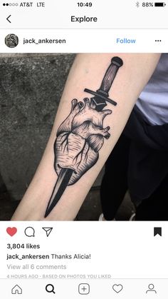 a black and white tattoo on the arm of a person with a knife in his heart