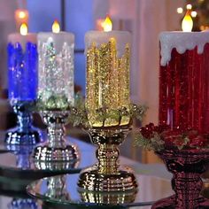 three lit candles sitting on top of a glass table