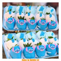 two trays filled with blue and white cupcakes