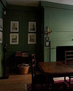 a table and chairs in a room with green walls