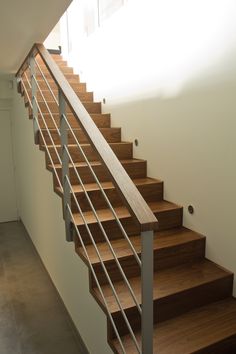 a set of wooden stairs with metal handrails