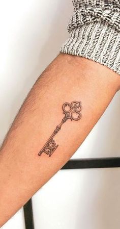 a person with a tattoo on their arm holding a key