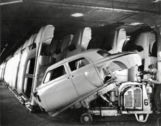 an old black and white photo of a car being worked on