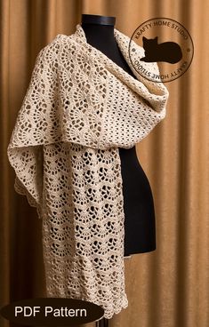 a crocheted shawl draped over a mannequin