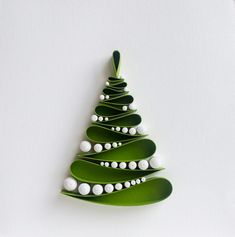 a green christmas tree shaped brooch with white pearls on it's sides and an ornament in the shape of a leaf