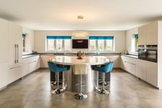 a kitchen with two stools and a table in it