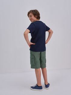 a young boy standing with his hands on his hips