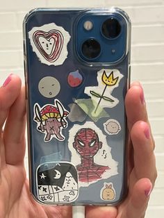 someone holding up their phone case with stickers on it