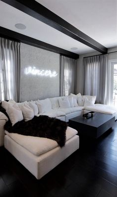 a living room filled with white furniture and windows