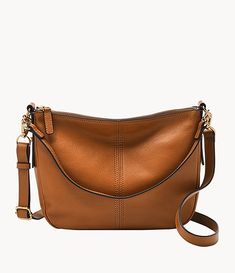 the cross body bag is tan leather and has an adjustable shoulder strap, with a gold metal